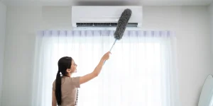 Mulher limpando ar-condicionado