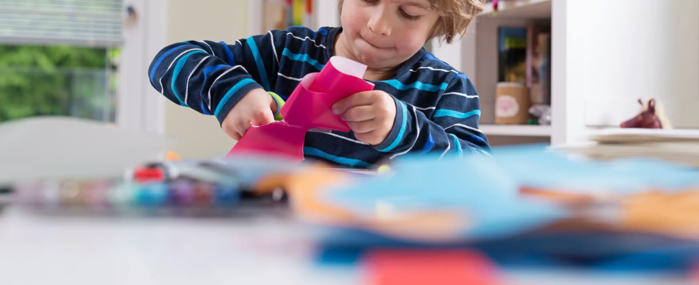 Criança cortando papel de presente
