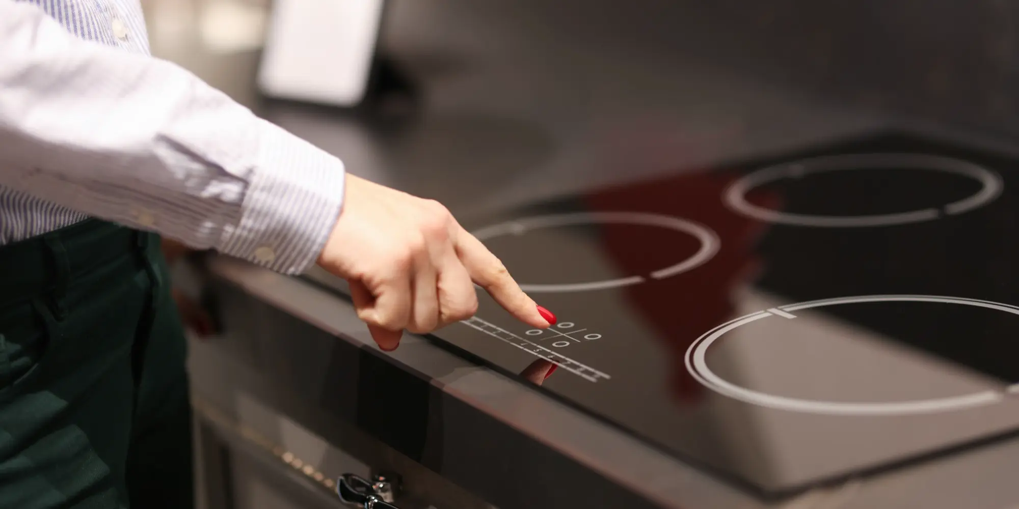 Mulher apontando para um cooktop de indução na mesa